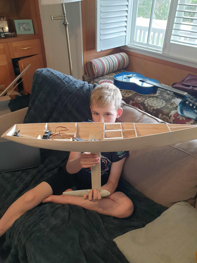 Andy Saunders and son holding a model yacht, balsa construction, Location: New Zealand