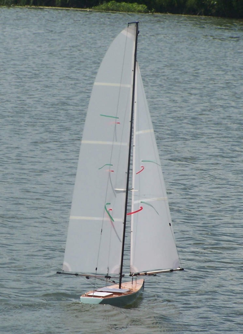 A racing sparrow sailing downwind on a flat water lake, sails winged either side, Location: USA