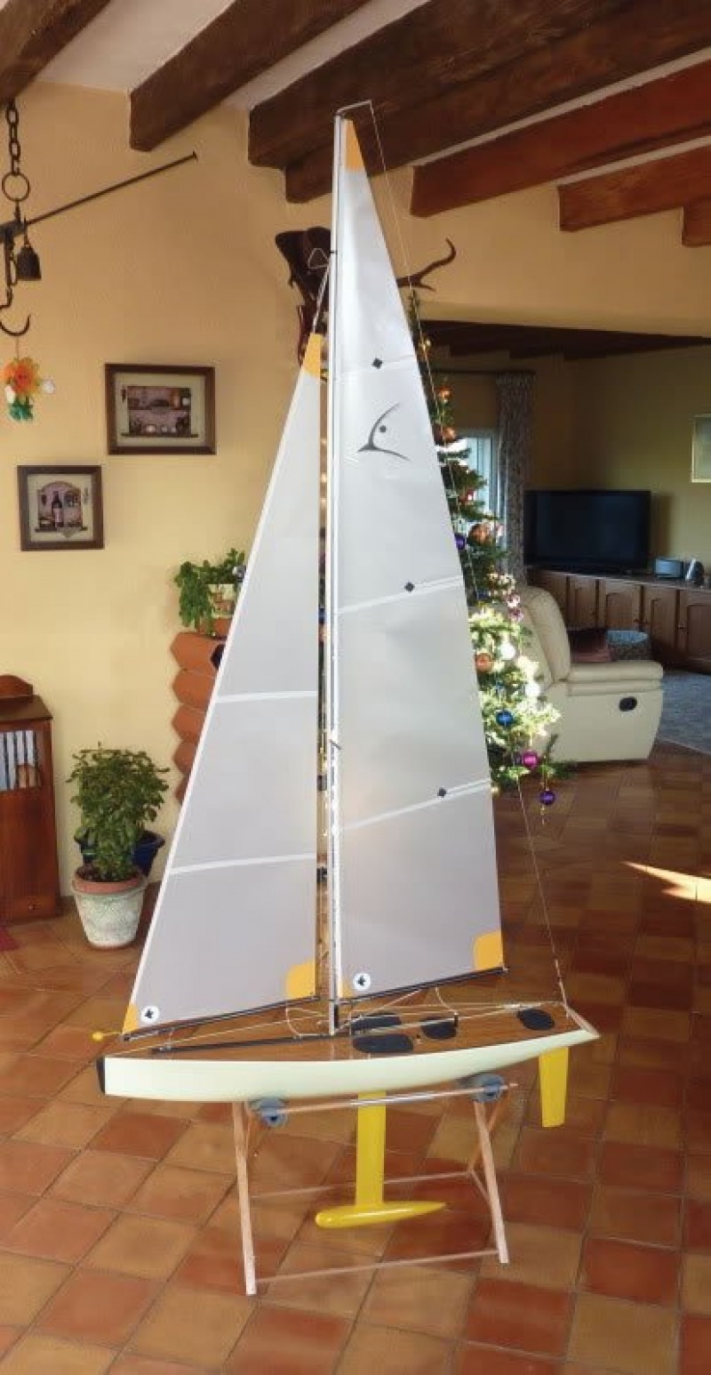 A one meter yacht, a racing sparrow design, cream coloured hull with yellow appendages and semi see-through sails, Location: France