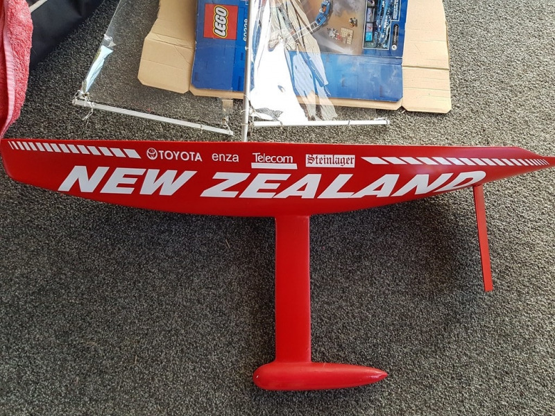 Jonathon Gillham's Racing Sparrow model yacht in bright red colour scheme with an old 90's styled graphics and logo font in bold white, Location: New Zealand