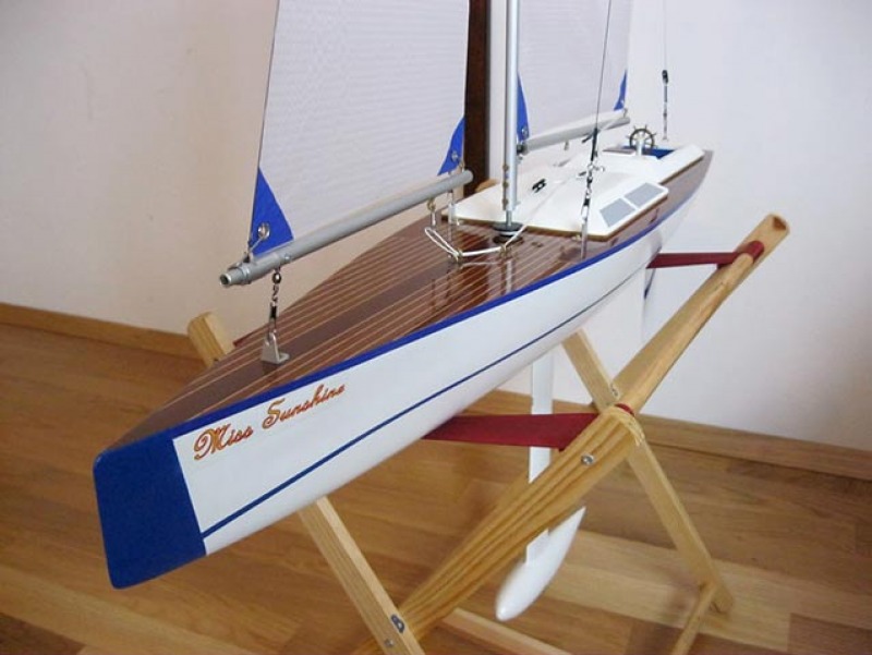 A beautiful model yacht called miss sunshine, white hull with blue accents sitting on a polished wooden floor, Location: Vienna, Austria
