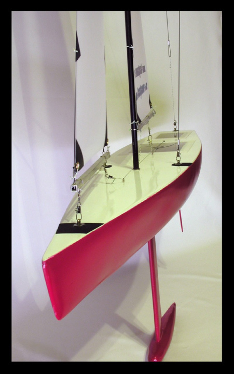 A red racing sparrow model yacht looking at the bow of the boat, Location: New Zealand