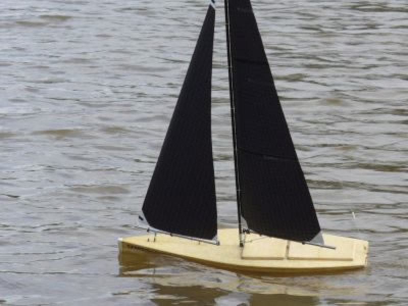 An 80% RG65 model yacht with black sails and wooden hull natual, Location: Auckland, New Zealand