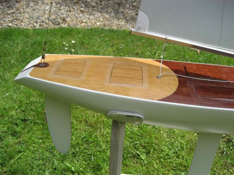 The stern of a model yacht with a varnished wooden deck with a dark circular pattern creating lovely sections and a quality aesthetic, Location: Auckland, New Zealand