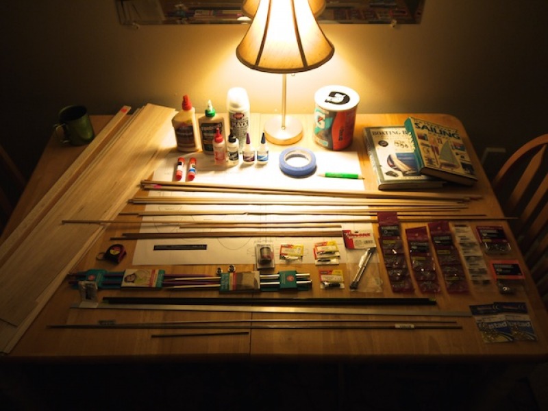 A moody image of the materials needed to build a racing sparrow model yacht, layed out very evenly