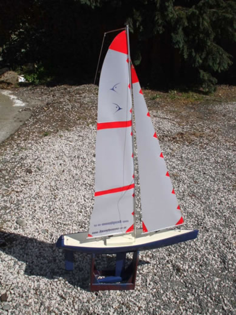 A sparkly blue model yacht hull with red and translucent sails, Location: Canterbury, New Zealand