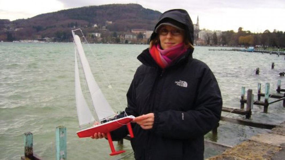 Racing Sparrow model yacht being held by a woman who is about to launch the boat for a sail